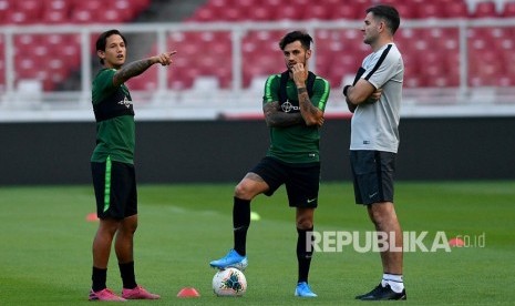 Pelatih Timnas Indonesia Simon McMenemy (kanan) berbincang dengan pemain Timnas Stefano Lilipaly (tengah) dan Irfan Bachdim sebelum berlatih di Stadion Utama Gelora Bung Karno, Jakarta, Ahad (1/9/2019).