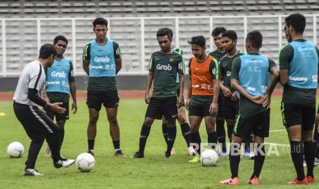 Pelatih Timnas Indonesia U-22 Indra Sjafri (kiri) memberikan instruksi kepada pemain saat sesi latihan di Lapangan Madya, Kompleks SUGBK, Senayan.