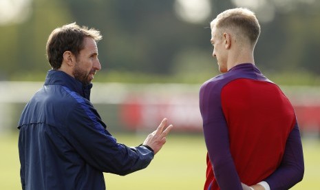 Pelatih timnas Inggris, Gareth Southgate (kiri) berbincang dengan kiper, Joe Hart saat sesi latihan di London, Senin (10/10).