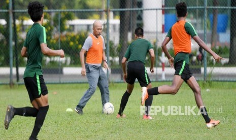 Pelatih Timnas U-18 Fakhri Husaini (kedua kiri) bermain bola bersama pemainnya saat latihan di Lapangan Becamex Binh Duong, Vietnam, Kamis (15/8/2019).