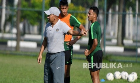 Pelatih Timnas U-18 Fakhri Husaini (kiri) memberikan arahan kepada pemainnya saat latihan di Lapangan Becamex Binh Duong, Vietnam, Selasa (13/8/2019).