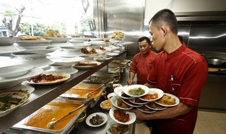 Pelayan bersiap menyajikan beragam makanan di sebuah rumah makan Padang.