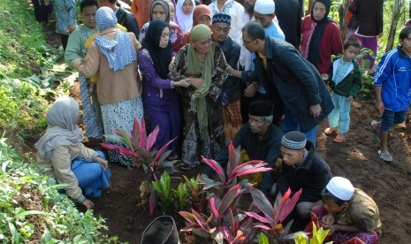 Pelayat dan keluarga memanjatkan doa seusai prosesi pemakaman seorang korban dugaan keracunan makanan massal, Didin Samsudin (58) di Desa Girijaya, Nagrak, Sukabumi, Jawa Barat, Selasa (19/1). 