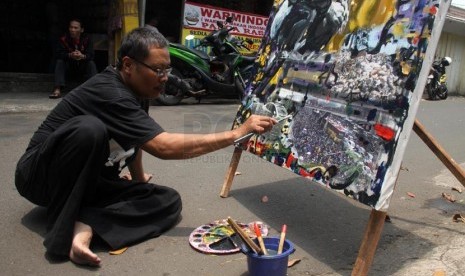 Pelukis Yahya TS melukis wajah Gubernur DKI Jakarta Joko Widodo atau Jokowi di Grogol, Jakarta Barat, Kamis (20/3).   (Republika/Yasin Habibi)