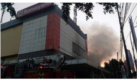 Pemadam kebakaran berusaha memadamkan api yang menyala di bagian belakang Gedung Ramayana Pasar Minggu, Kamis (18/5) pagi.