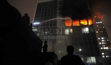 Pemadam kebakaran berusaha memadamkan kebakaran di Gedung Wisma Kosgoro, Jalan Thamrin, Jakarta Pusat, Senin (9/3).  (Republika/Agung Supriyanto)