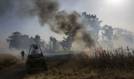  Pemadam kebakaran Israel memadamkan api yang berasal dari alat pembakar yang diluncurkan dari Jalur Gaza, dekat pagar perbatasan Israel dan Gaza, Rabu, (15/5). Rakyat Palestina menandai peringatan Hari Nakba ke-71 dengan berdemonstrasi di Tepi Barat yang diduduki Israel dan Jalur Gaza.