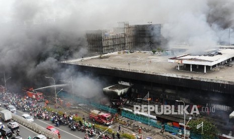 Pemadam kebakaran terus berusaha menjinakkan si jago merah yang membakar pusat perbelanjaan proyek Senen Jakarta, Kamis (19/1). 