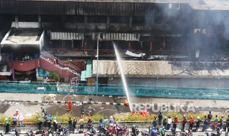 Pemadam kebakaran terus berusaha menjinakkan si jago merah yang membakar pusat perbelanjaan proyek Senen Jakarta, Kamis (19/1). 