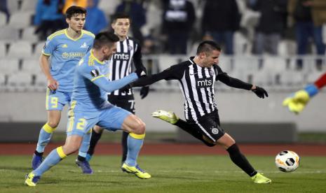 Pemai Partizan Belgrade (kaus putih-hitam) beraksi dalam sebuah pertandingan. Manajemen Partizan Belgrade memutuskan memangkas gaji pemain dan direksi klub hingga 50 persen selama pandemi corona.