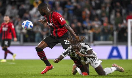 Pemain AC Milan Fikayo Tomori (kiri) dan penggawa Juventus Moise Kean bersaing memperebutkan bola dalam pertandingan sepak bola Serie A antara Juventus dan AC Milan, di stadion Turin Allianz, Italia, Senin (20/9).