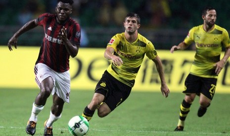 Pemain AC Milan Franck Kessie (kiri) berebut bola dengan dua pemain Borussia Dortmund, Christian Pulisic dan Gonzalo Castro, pada laga International Champions Cup (ICC) di Stadion Universitas Town Sports Centre, Guangzhou, Cina, 18 Juli 2017.