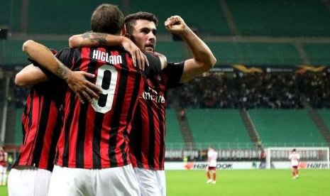 Pemain AC Milan Gonzalo Higuain (membelakangi kamera) merayakan kemenangan bersama Patrick Cutrone (kanan) yang telah menyumbang dua gol bagi timnya dalam laga Grup F melawan Olympiakos di San Siro Stadium, Italia, Kamis. Milan unggul 3-1 dengan dua gol sumbangan Cutrone.