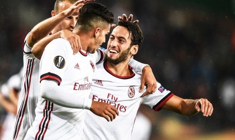 Pemain AC Milan Hakan Calhanoglu (kanan) dan Andre Silva (kiri) merayakan gol ke gawang Austria Wina, Jumat (15/9) dini hari WIB. Milan berpesta gol ketika mengalahkan Austria Wina dengan skor 5-1 pada laga pembuka Grup D Liga Europa di Stadion Ernst Happel.