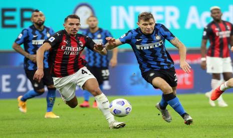 Pemain AC Milan Ismael Bennacer (kiri) berduel dengan penggawa Inter Milan Nicolo Barella pada laga lanjutan Liga Italia Serie A 2020/2021 di Giuseppe Meazza, Ahad (18/10).