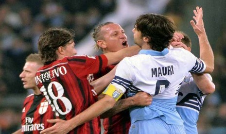 Pemain AC Milan, Philippe Mexes (tengah), terlibat adu mulut dengan pemain Lazio, Stefano Mauri (kanan), dalam laga Serie A Italia di Stadion Olimpico, Roma, Sabtu (24/1).