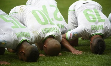 Pemain Aljazair merayakan gol dengan sujud syukur di pinggir lapangan.