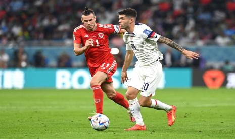 Pemain Amerika Serikat Christian Pulisic (kanan) mencoba melewati pemain Wales Gareth Bale (kiri) pada pertandingan fase Grup B Piala Dunia Qatar 2022 di Stadio Ahmad bin Ali, Doha, Qatar, Selasa (22/11) dini hari WIB.