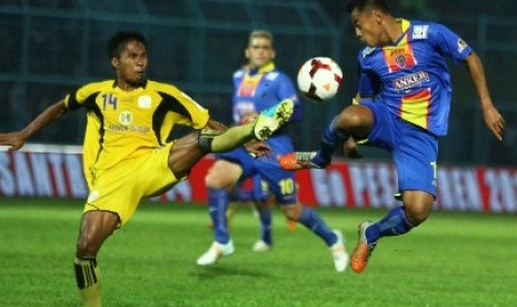 Pemain Arema Indonesi Cronous, Samsul Arif (kanan) berebut bola dengan pesepakbola Barito Putra, Faturrahman.