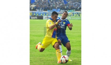 Pemain Arema Malang Benny Wahyudi (kiri) berebut bola dengan pemin Persib Bandung Atep (kanan) pada laga lanjutan Indonesia Super League di Stadion Si Jalak Harupat, Kabupaten Bandung, Ahad (13/4). (foto: Septianjar Muharam)