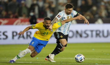 Pemain Argentina Lionel Messi (kanan) dan pemain Brasil Matheus Cunha berebut bola selama pertandingan sepak bola kualifikasi untuk Piala Dunia FIFA Qatar 2022 di stadion Bicentenario di San Juan, Argentina, Rabu (17/11).