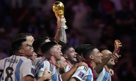  Pemain Argentina Lionel Messi mengangkat trofi pada pertandingan sepak bola final Piala Dunia antara Argentina dan Prancis di Stadion Lusail di Lusail, Qatar,  Ahad (18/12/2022).