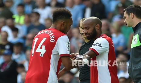  Pemain Arsenal Alexandre Lacazette, kanan, menerima ban kapten dari pemain Arsenal Pierre-Emerick Aubameyang sebelum masuk ke lapangan saat pertandingan sepak bola Liga Inggris antara Manchester City dan Arsenal di stadion Etihad di Manchester, Inggris, Sabtu (28/8). 