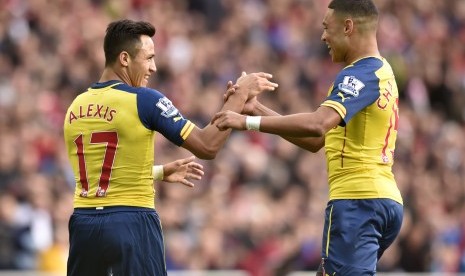 Pemain Arsenal Alexis Sanchez (kiri) bersama Alex Oxlade-Chamberlain merayakan gol ke gawang Sunderland, Sabtu (25/10).