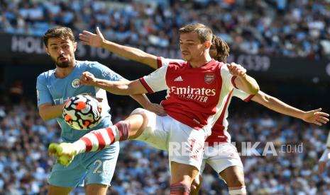  Pemain Arsenal Cedric Soares, kanan, berebut bola dengan pemain Manchester City Bernardo Silva dalam pertandingan sepak bola Liga Inggris antara Manchester City dan Arsenal di stadion Etihad di Manchester, Inggris, Sabtu (28/8). 