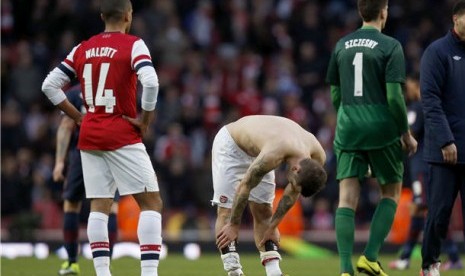 Pemain Arsenal, Jack Wilshere (tengah), bersama rekannya Theo Walcott (kiri) dan kiper Wojciech Szczesny tertunduk lesu usai menelan kekalahan 0-1 dari Blackburn Rovers di putaran kelima Piala FA di Stadion Emirates, London, Sabtu (16/2). 