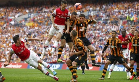 Pemain Arsenal, Laurent Koscielny (dua kiri), loncat melepaskan sundulan saat menghadapi Hull City di final Piala FA di Stadion Wembley, London, Sabtu (17/5). 