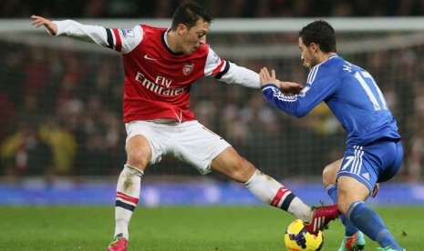 Pemain Arsenal Mesut Ozil (kiri) berusaha menghadang pemain Chelsea Eden Hazard pada pertandingan Liga Inggris di Stadion Emirates,London Senin (23/12).