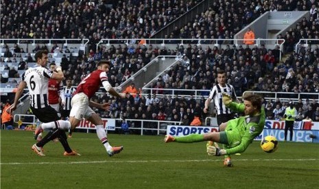 Pemain Arsenal, Olivier Giroud (tengah), melepaskan sundulan menjebol gawang Newcastle United dalam laga Liga Primer Inggris di St James Park, Newcastle, Ahad (29/12).