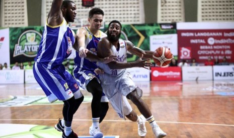 Pemain asing CLS Knights Ashton Smith berusaha melewati penjagaan dua pemain Satria Muda Pertamina pada gim pertama semifinal IBL Pertalite 2017 di GOR Kertajaya Indah, Surabaya, Rabu (19/4).