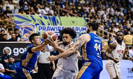 Pemain asing Pelita Jaya Kevin Mc Daniels menerobos di antara penjagaan dua pemain Prawira Harum Bandung dalam pertandingan pertama final four IBL 2024 di Bandung, Kamis (25/7/2024) malam. Pelita Jaya menang 84-80.