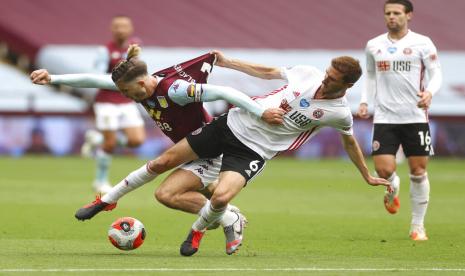 Pemain Aston Villa, Jack Grealish (kiri), berebut bola dengan pemain Sheffield United, Chris Basham, dalam laga Liga Primer Inggris di Stadion Villa Park, Birmingham, Rabu (17/6).