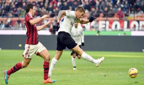 Pemain Atalanta, German Gustavo Denis (kanan), membobol gawang AC Milan saat kedua tim bersua di laga Serie A Italia di Stadion  Giuseppe Meazza, Milan, Ahad (18/1). 