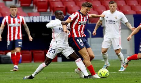 Pemain Atletico Madrid Marcos Llorente berebut bola dengan pemain Real Madrid Ferland Mendy dalam Derbi Madrid di Stadion  Wanda Metropolitano Ahad (7/3). 