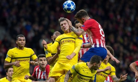 Pemain Atletico Madrid, Saul Niguez (kanan), berduel udara dengan pemain Borussia Dortmund dalam lanjutan laga Grup A Liga Champions di Stadion Wanda Metropolitano, Madrid, Spanyol, Selasa (6/11). 