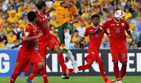 Pemain Australia Mark Milligan (tengah) menanduk bola di tengah kepungan pemain Oman dalam lanjutan Piala Asia 2015 Grup A, Selasa (13/1).