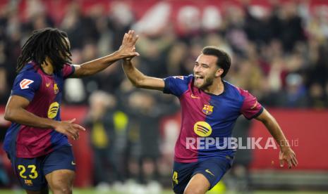 Pemain Barcelona Eric Garcia merayakan golnya bersama Jules Kounde, kiri, setelah mencetak gol keempat bagi timnya dalam pertandingan La Liga Spanyol antara Sevilla dan FC Barcelona di stadion Ramon Sanchez Pizjuan di Seville, Spanyol, Senin, 10 Februari 2025.  