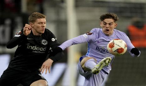 Pemain Barcelona Gavi, kanan, berduel memperebutkan bola dengan pemain Frankfurt Kristijan Jakic pada pertandingan leg pertama perempat final Liga Europa antara Eintracht Frankfurt dan Barcelona di Commerzbank Arena di Frankfurt, Jerman, Kamis, 7 April 2022.