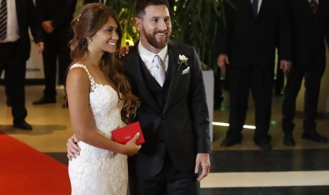 Pemain Barcelona, Lionel Messi (kanan), bersama istrinya, Antonella Roccuzzo (kiri), berpose di depan awak media usai menggelar acara pernikahan di Rosario, Santa Fe, Argentina, Jumat (30/6). 