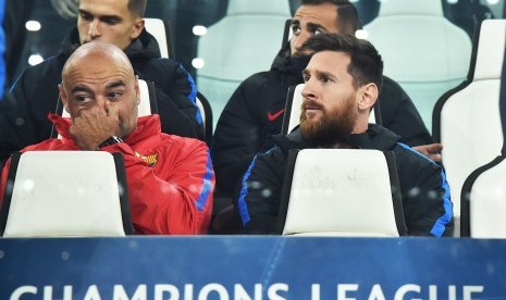 Pemain Barcelona Lionel Messi (kanan) duduk di bangku cadangan sebelum pertandingan sepak bola kualifikasi Grup D Liga Champions antara Juventus FC dan FC Barcelona di Stadion Allianz, Turin, Italia, Kamis (23/11) dini hari WIB. 