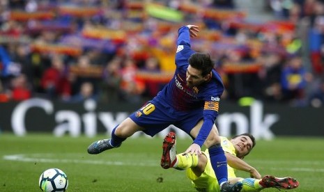   Pemain Barcelona Lionel Messi (kiri) saat berebut bola dengan pemain Getafe, Mauro Arambarri di Camp Nou, Ahad (11/2) waktu setempat 