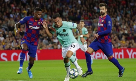 Pemain Barcelona Nelson Semedo, kiri, mencoba menghentikan pemain Inter Milan Lautaro Martinez, tengah, di penyisihan grup F Liga Champions, di Camp Nou Barcelina, Spanyol, Kamis (3/10).