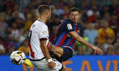  Pemain Barcelona Robert Lewandowski, kanan, menembak melewati pemain Rayo Florian Lejeune selama pertandingan sepak bola La Liga Spanyol antara Barcelona dan Rayo Vallecano di stadion Camp Nou di Barcelona, ??Spanyol, Sabtu, 13 Agustus 2022.