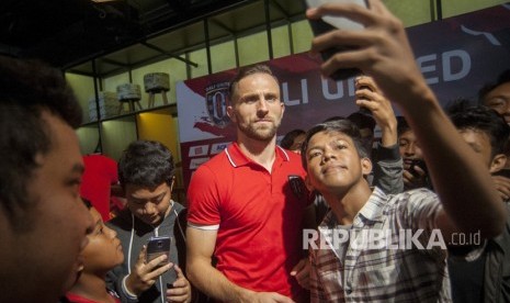 Pemain baru Bali United, Ilija Spasojevic (tengah) berfoto dengan para pendukung klub sepak bola itu seusai perkenalan pemain baru di Denpasar, Kamis (14/12).