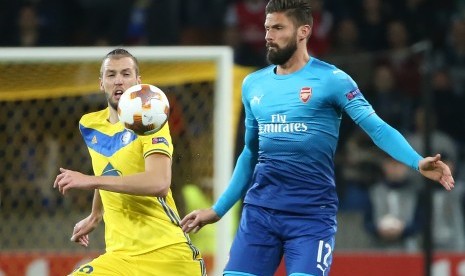 Pemain BATE Nemanja Milunovic (kiri) berusaha menghalau striker Arsenal Olivier Giroud (kanan) ketika kedua tim berhadapan pada penyisihan Grup H Liga Europa di Borisov, Belarusia, Jumat (29/9) dini hari WIB. 