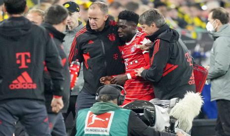 Bek Bayern Muenchen, Alphonso Davies, tengah, meninggalkan lapangan setelah cedera saat pertandingan sepak bola Bundesliga Jerman antara Borussia Dortmund dan Bayern Muenchen di Dortmund, Jerman, Sabtu, 10 Oktober 2022.